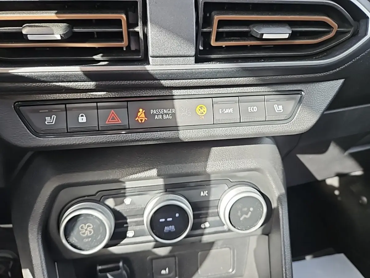 Vue rapprochée du tableau de bord central du Dacia Jogger 2024, montrant les commandes de climatisation et boutons fonctionnels.