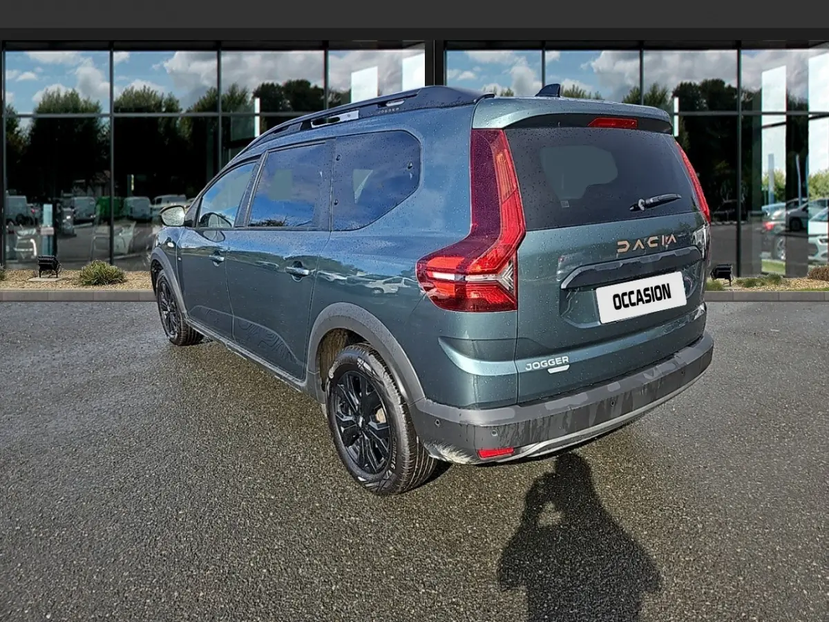 Vue 3/4 arrière droite d'un Dacia Jogger vert 2024 avec jantes noires et feux arrière en forme de L.