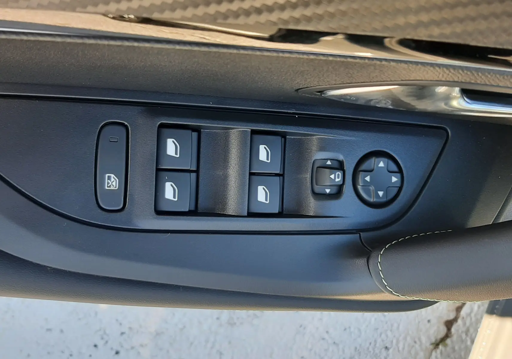 Panneau de commandes des vitres et rétroviseurs côté conducteur du Peugeot 2008 gris Selenium, finition GT 2025.
