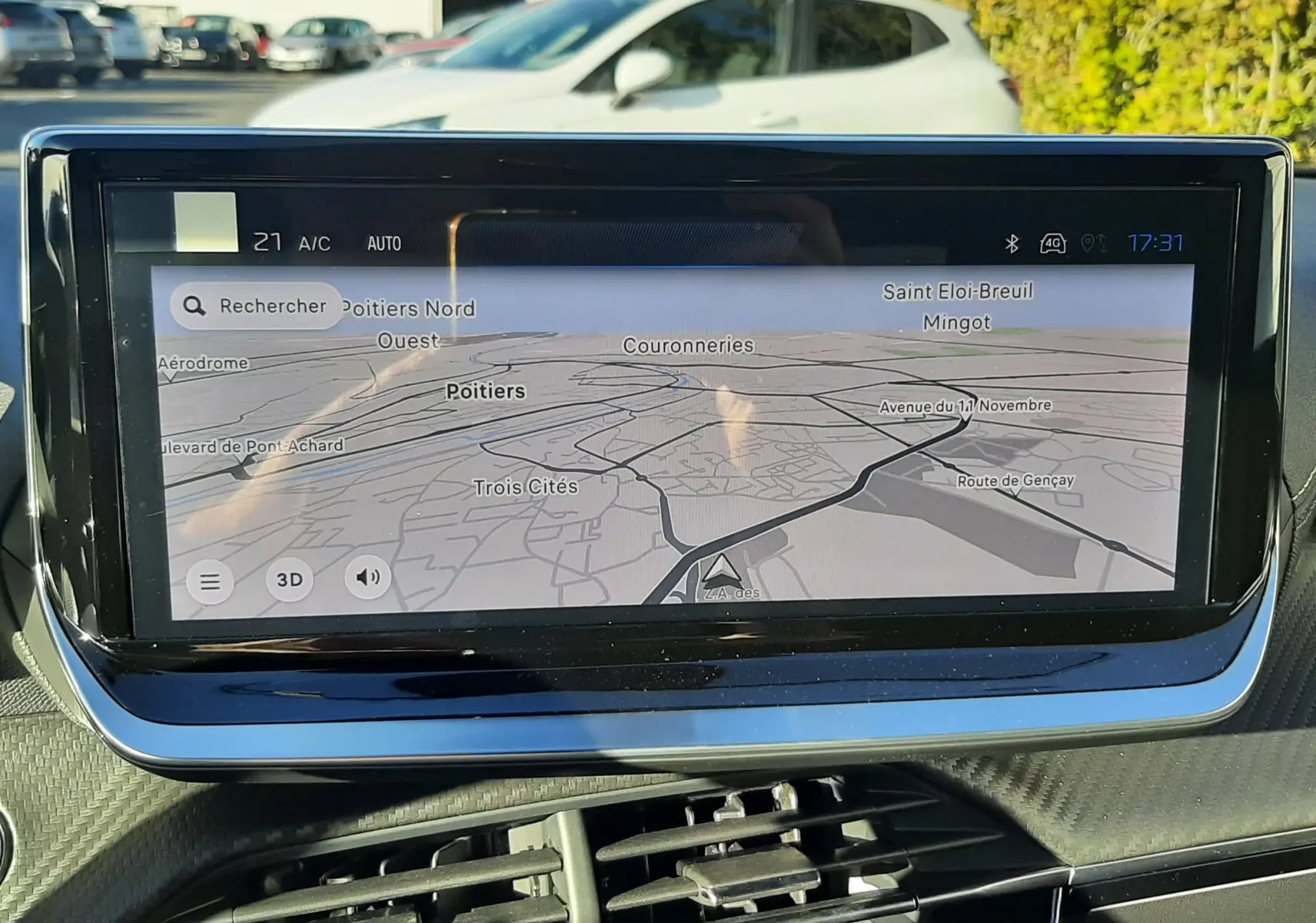 Écran tactile central du tableau de bord du Peugeot 2008 gris Selenium affichant la navigation GPS en extérieur lumineux.