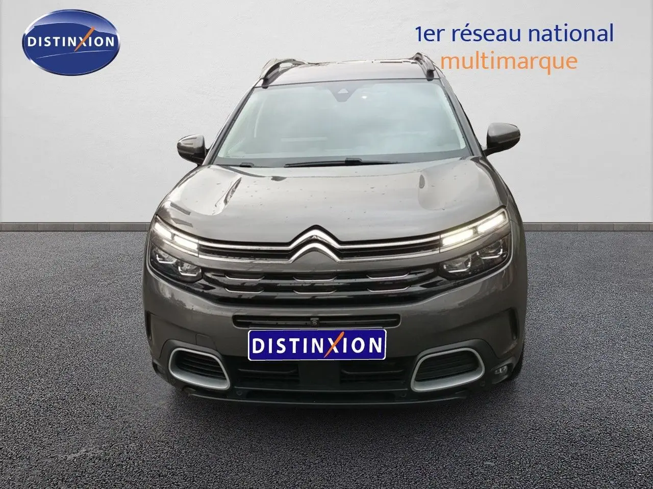 Vue frontale du Citroën C5 Aircross hybride rechargeable 2022 en gris platinium avec feux LED allumés.