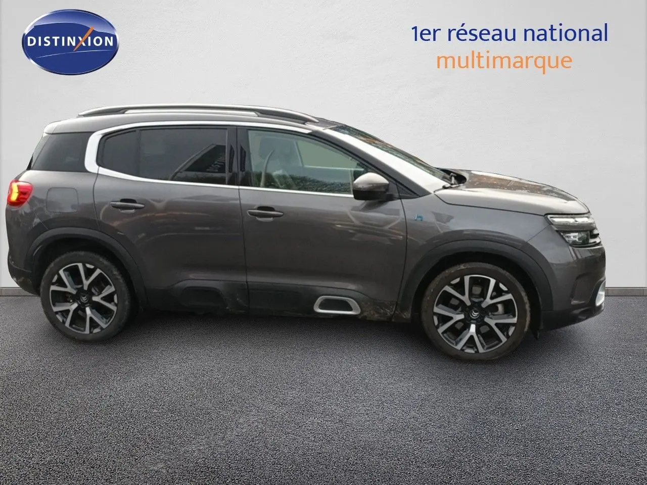 Vue de profil côté gauche d'un Citroën C5 Aircross hybride rechargeable 2022 gris platinium avec jantes alliage distinctives.