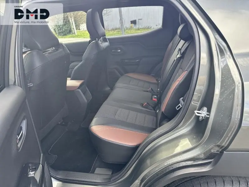 Vue côté droit de l'habitacle arrière du Suzuki Vitara 2026, sièges tissu et cuir noir et marron, porte ouverte.