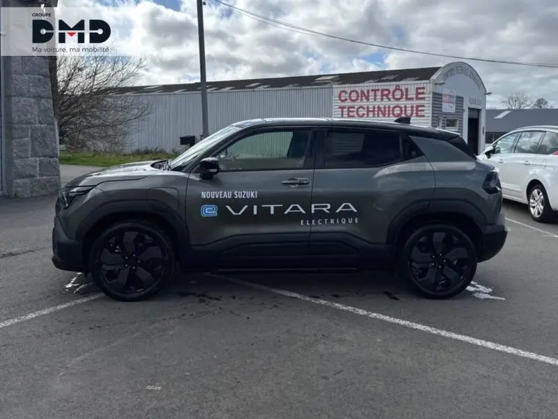 Vue latérale gauche du Suzuki Vitara électrique 2026 en vert Land Breeze avec toit noir et jantes noires.