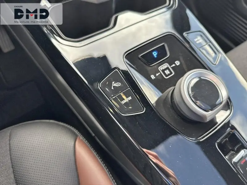 Gros plan sur la console centrale noire brillante du Suzuki Vitara 2026, avec sélecteur rotatif et bouton mode neige visible.