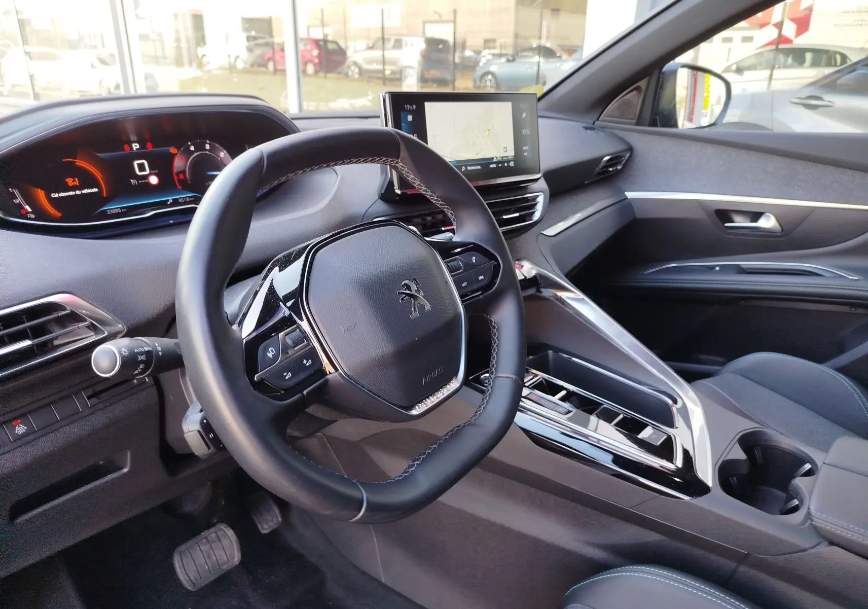 Intérieur du Peugeot 3008 2023 vu côté conducteur, volant compact, écran tactile central et tableau de bord numérique.