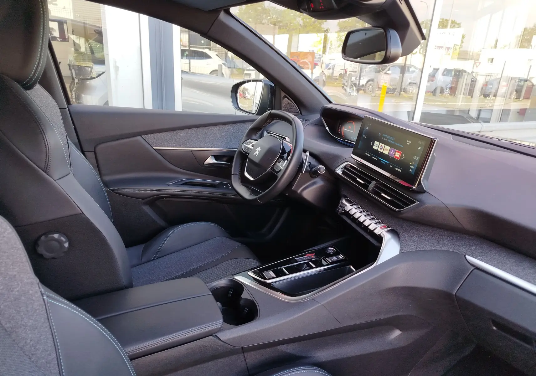 Vue intérieure côté conducteur du Peugeot 3008 gris Platinium 2023, avec tableau de bord numérique et écran tactile central.