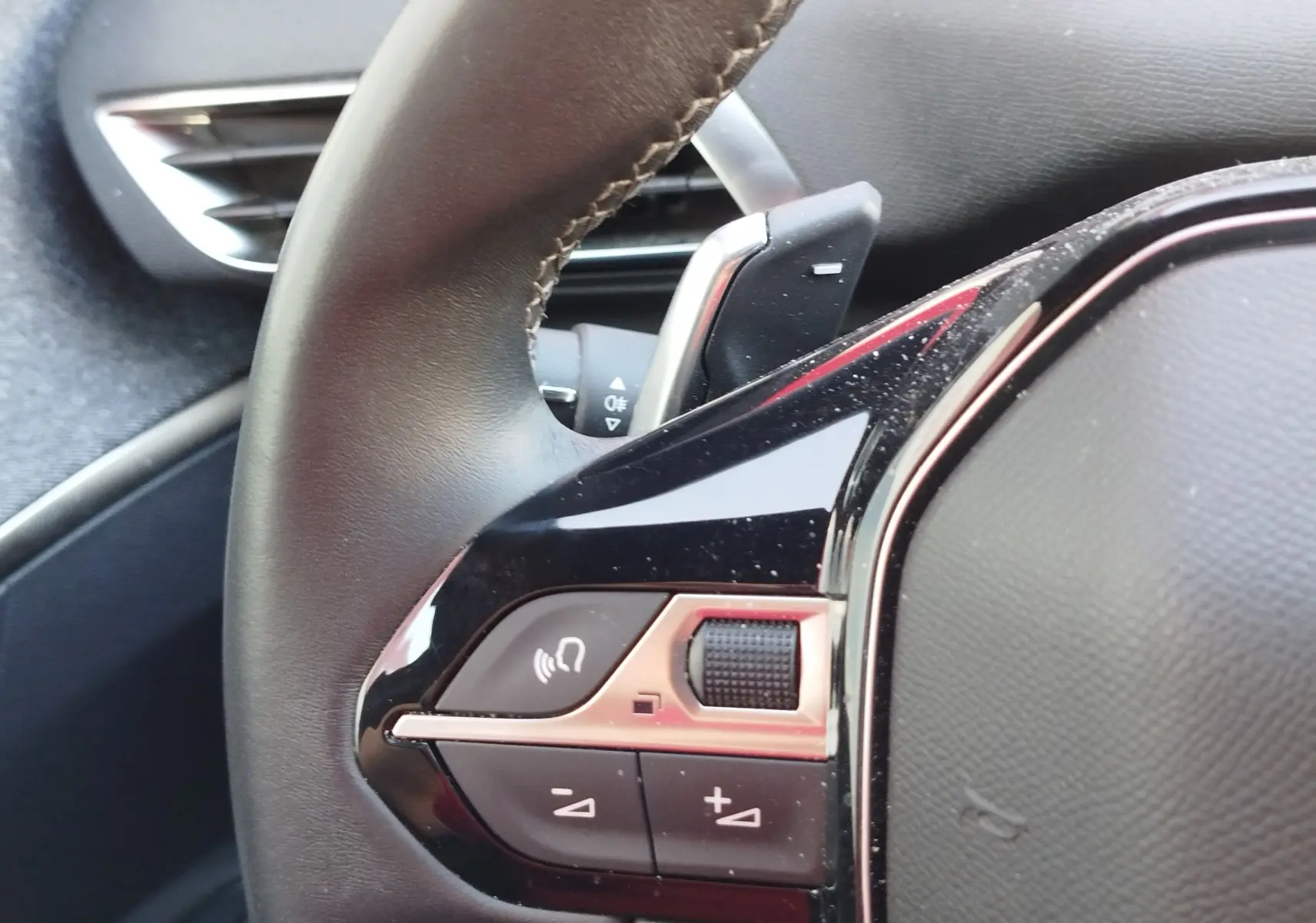 Gros plan sur les commandes noires et chrome du volant du Peugeot 3008 2023, finition Allure Pack.