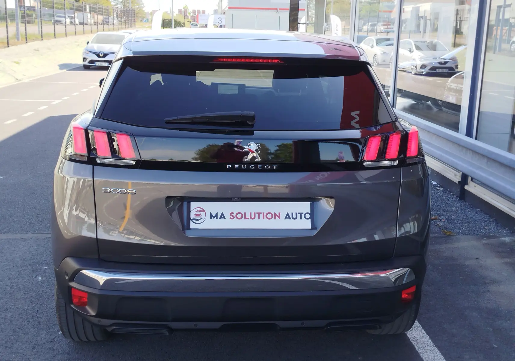 Vue arrière d'un Peugeot 3008 gris Platinium 2023 avec feux arrière à trois griffes et vitre arrière teintée.