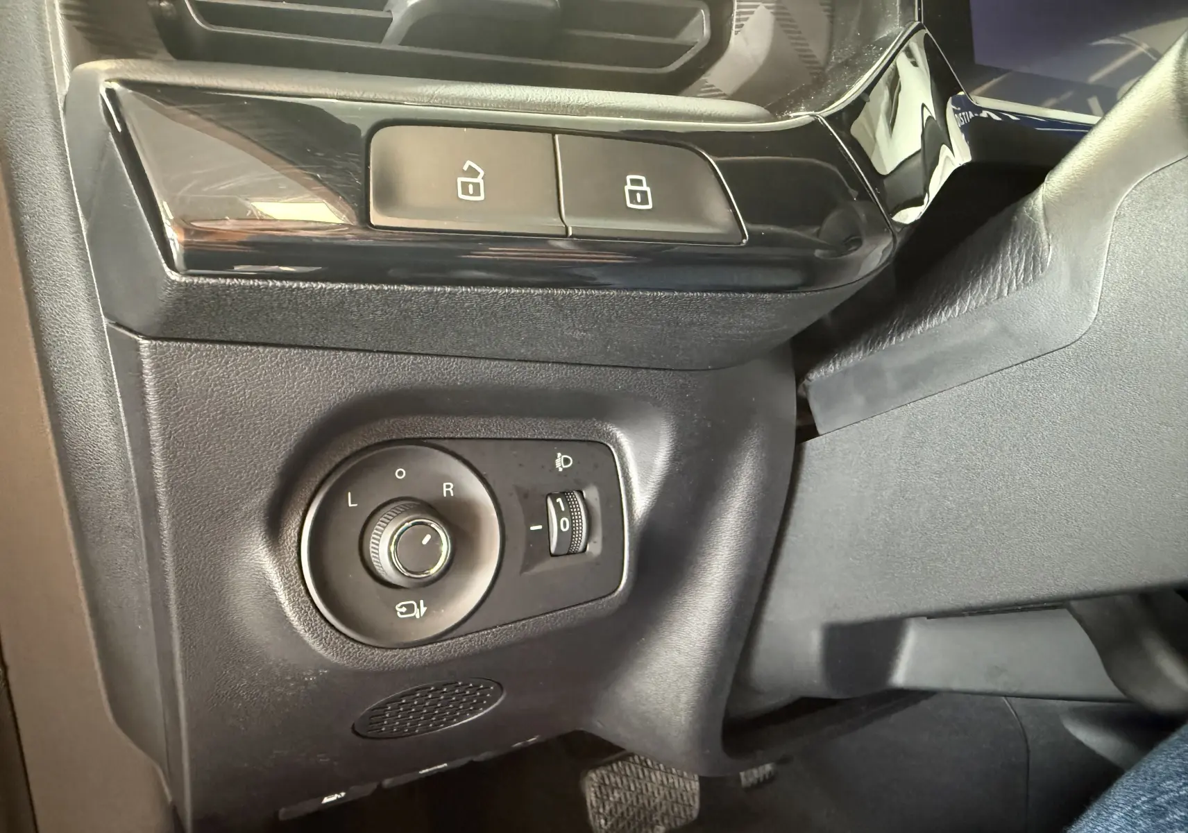 Détail des commandes de réglage des rétroviseurs et des boutons de verrouillage sur le côté gauche intérieur du MG3 gris.