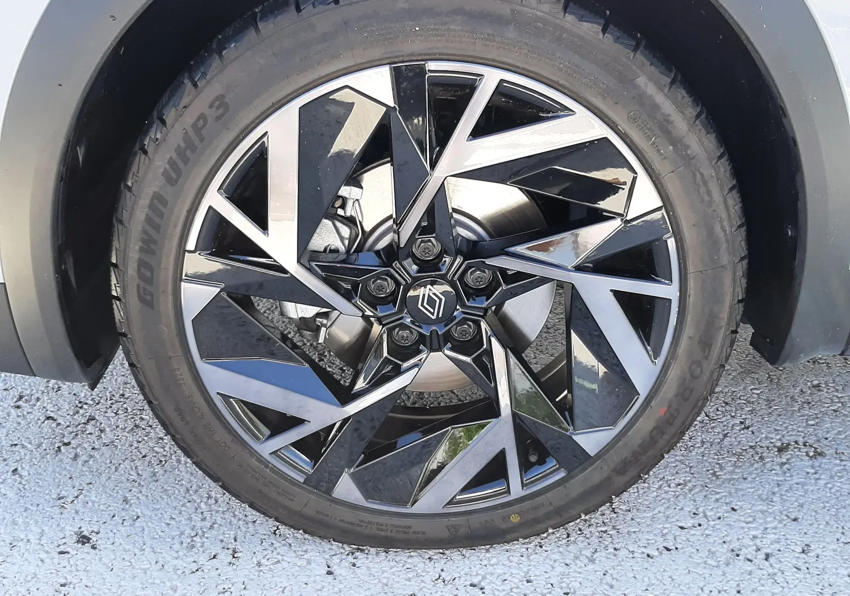 Gros plan sur la roue avant droite du Renault Symbioz gris Rafale, jante alliage noire et argent au design géométrique.
