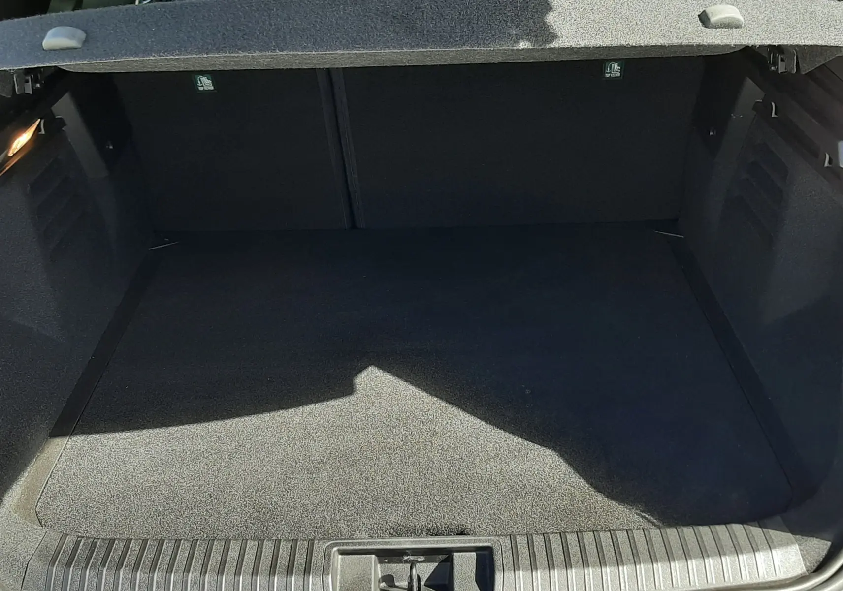 Coffre ouvert vu de l'arrière d'une Renault Symbioz gris Rafale, montrant l'espace de chargement vide.
