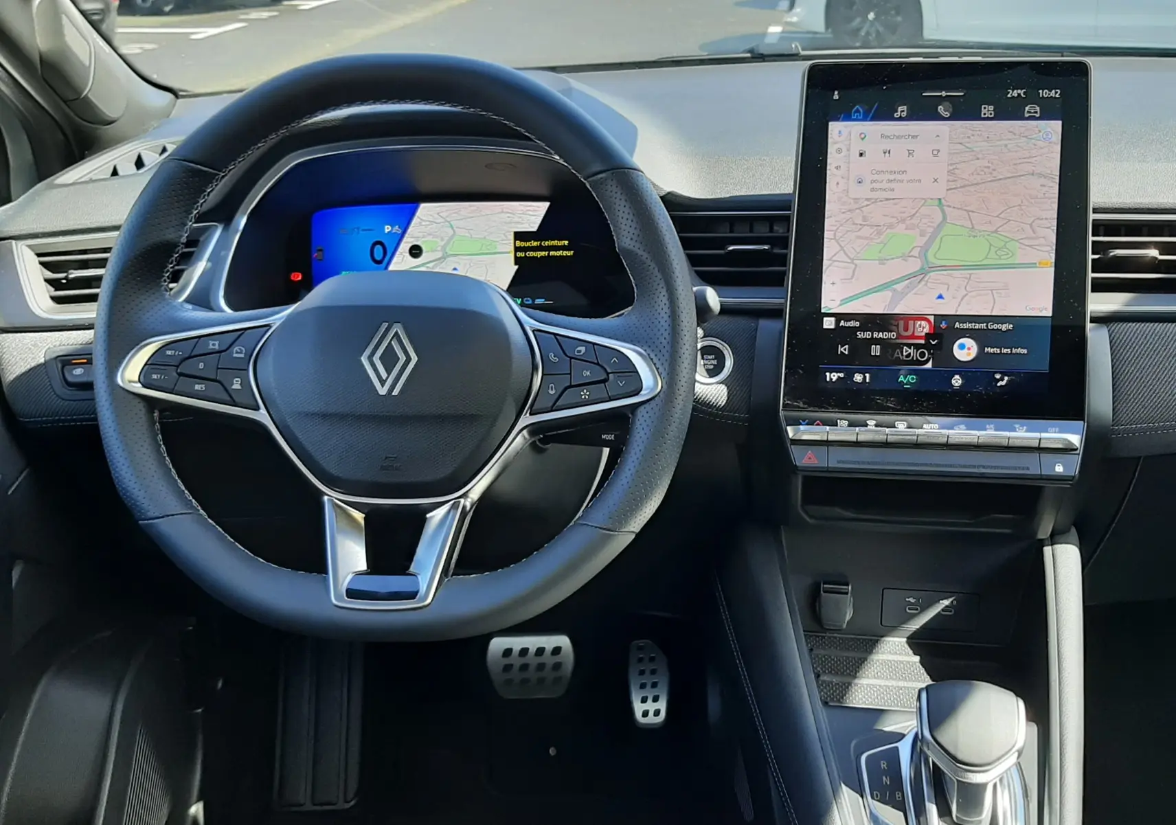 Vue intérieure frontale du tableau de bord de la Renault Symbioz gris Rafale, avec volant multifonction et écran tactile vertical.