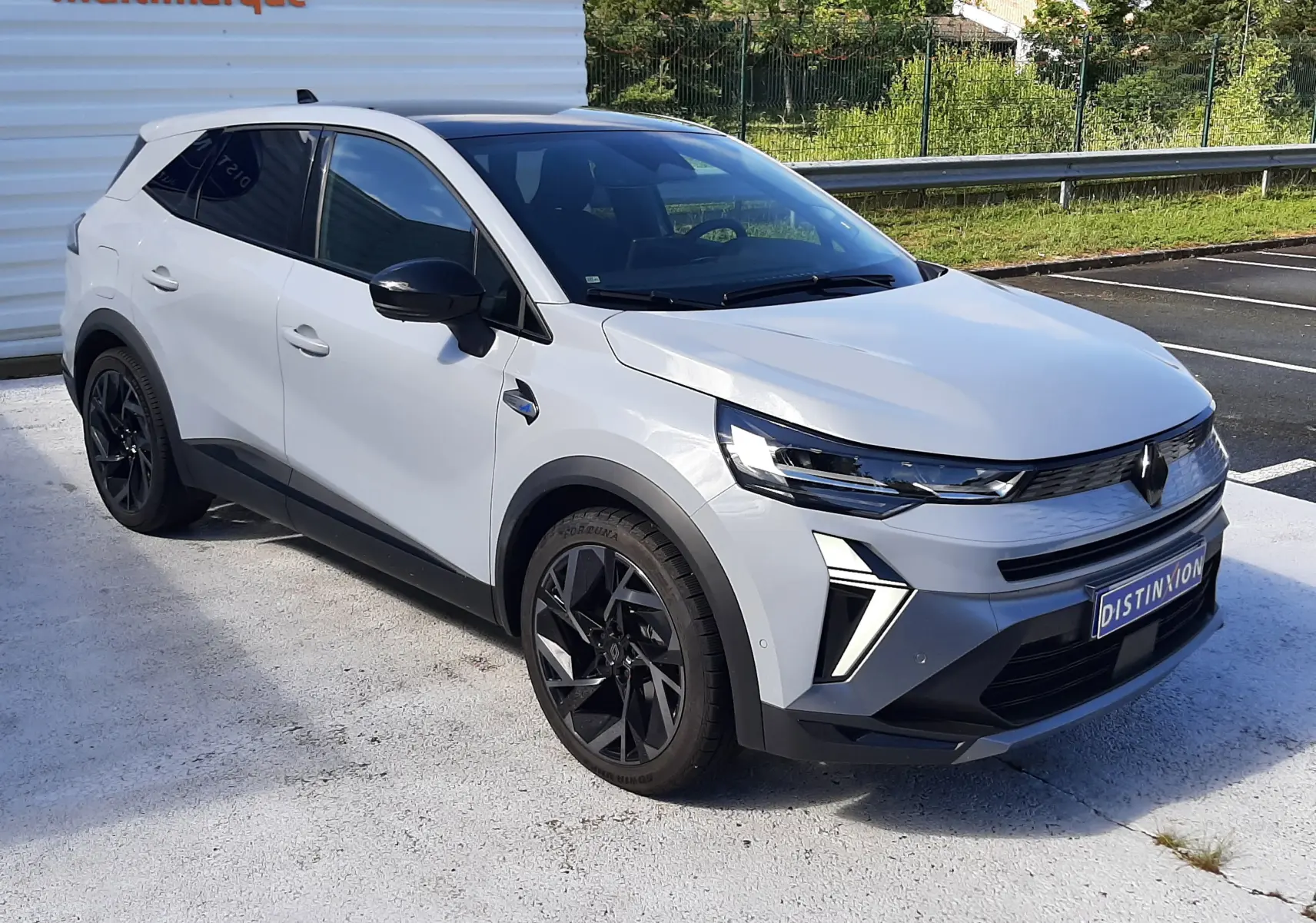 Vue 3/4 avant du Renault Symbioz E-Tech Full Hybrid gris rafale avec jantes noires et détails noirs contrastants.