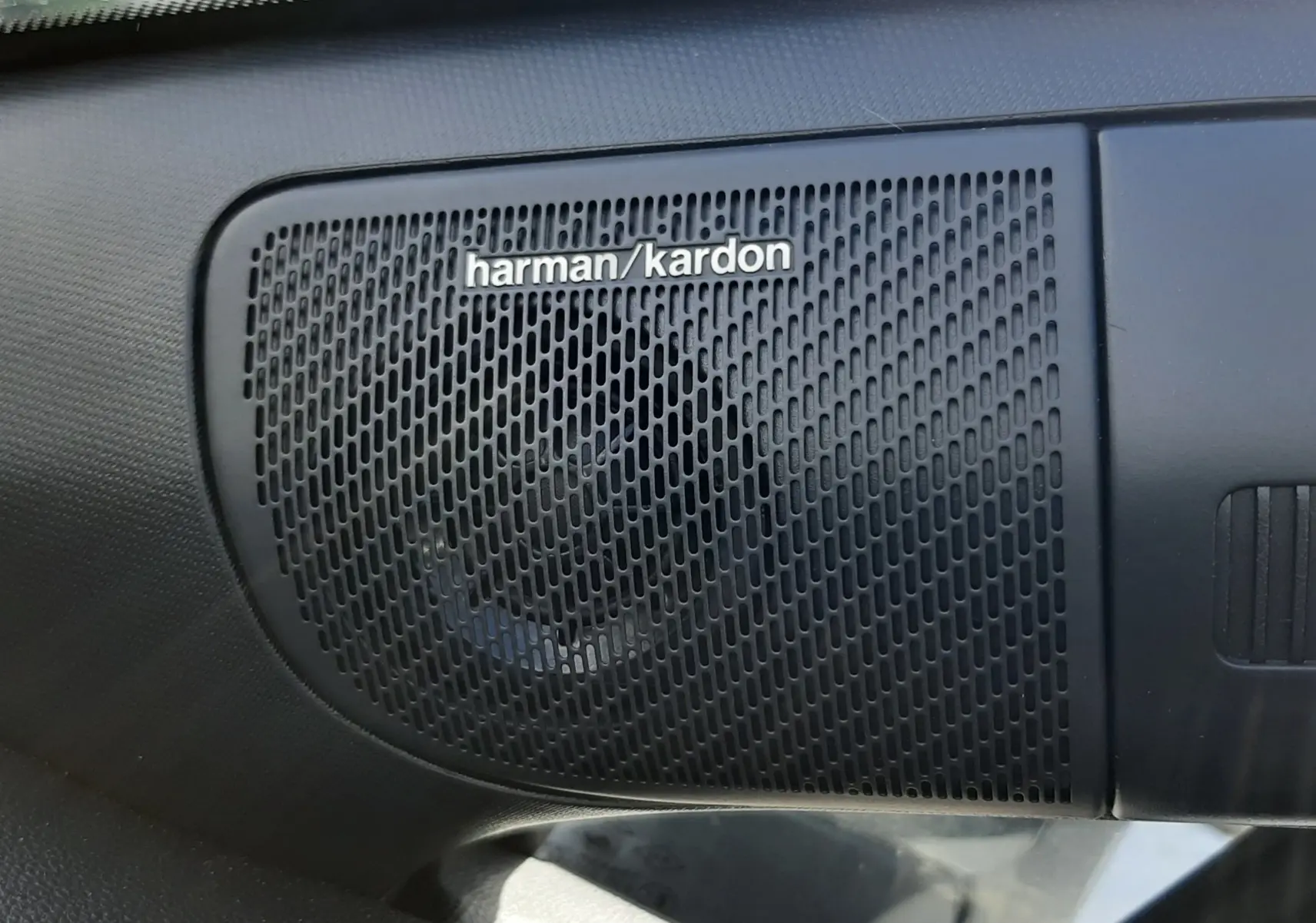 Gros plan sur le haut-parleur Harman/Kardon intégré dans l'habitacle du Renault Symbioz gris Rafale.