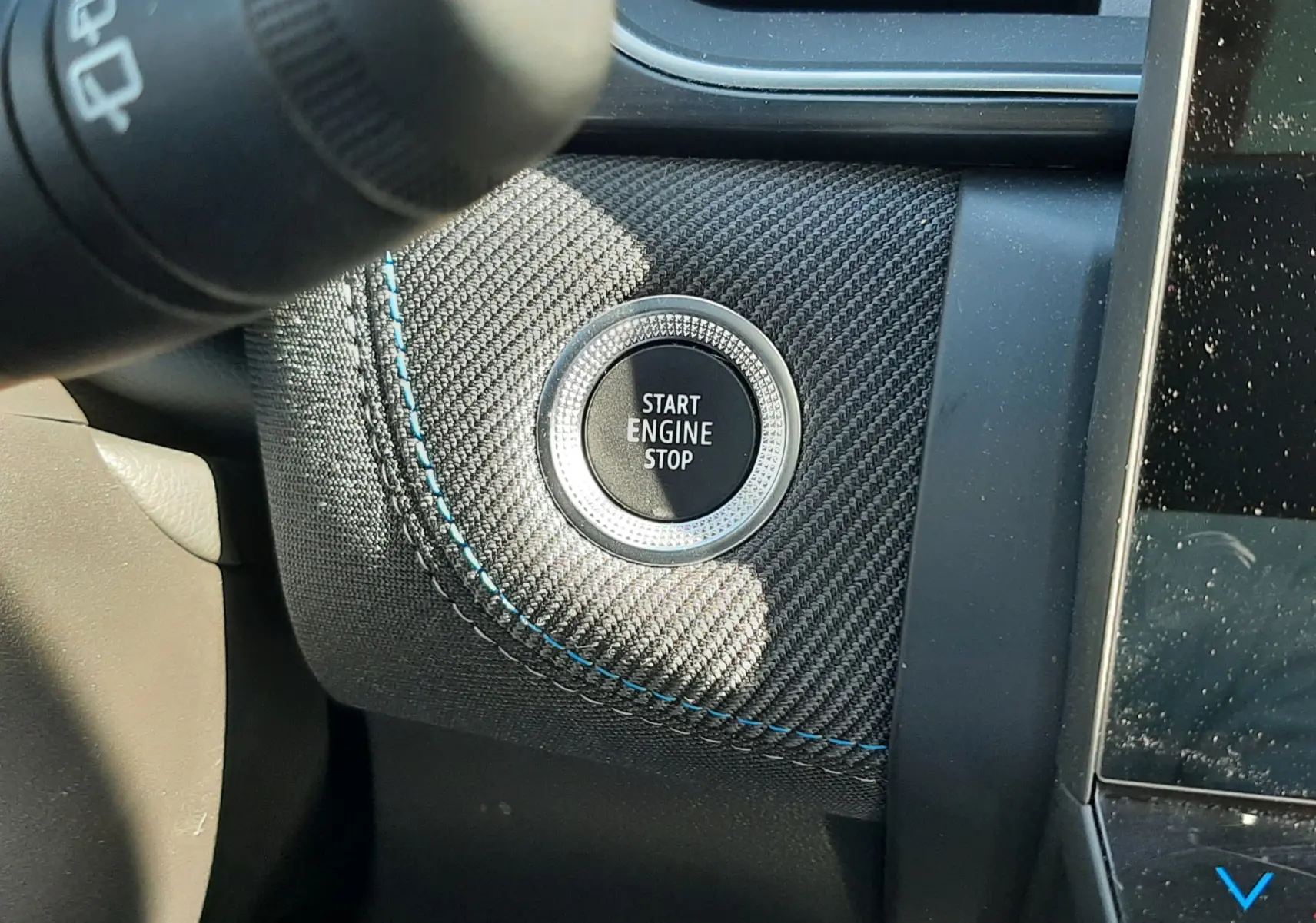 Détail du bouton Start Engine Stop sur tableau de bord en carbone avec surpiqûres bleues du Renault Symbioz gris Rafale.