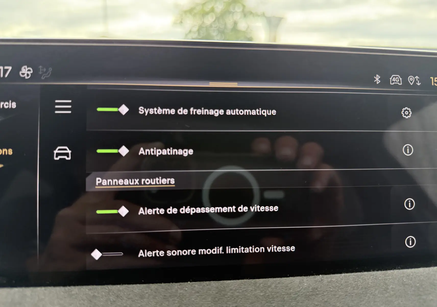 Écran tactile intérieur du DS3 hybride 2025 affichant les options d'aide à la conduite, avec reflet de la main.