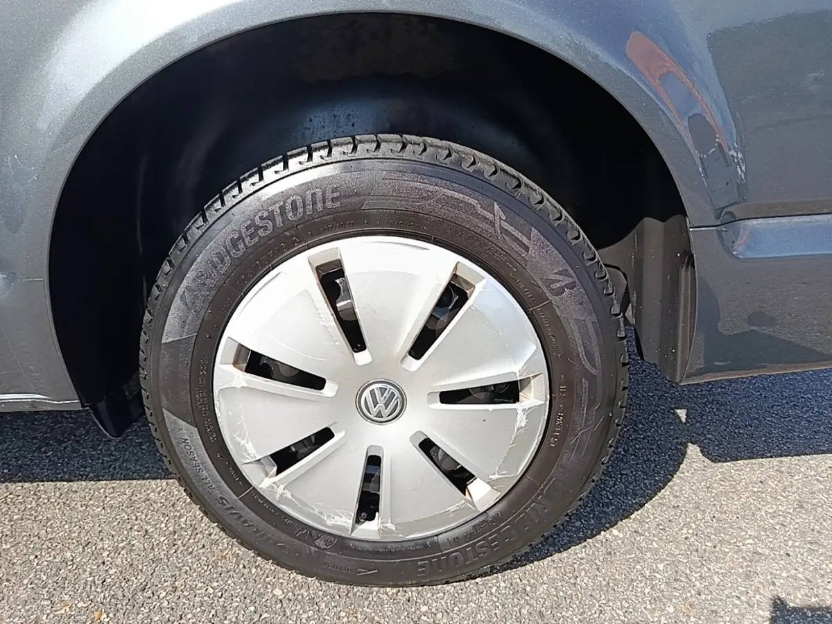 Gros plan sur la roue avant droite d’un Volkswagen Transporter gris foncé avec enjoliveur VW et pneu Bridgestone.