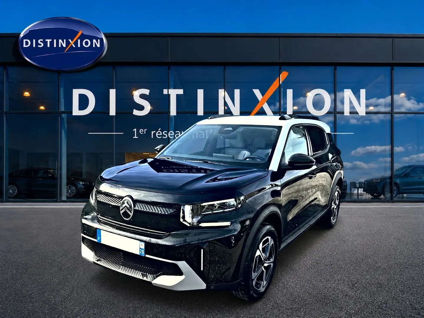 Citroën C3 Aircross noir vue 3/4 avant droit avec toit blanc et jantes alu devant vitrine Distinxion.