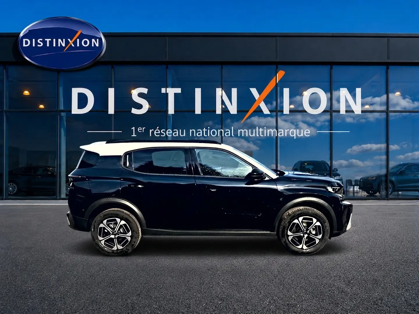 Vue latérale droite d'un Citroën C3 Aircross noir avec toit blanc, jantes alu et barres de toit visibles.