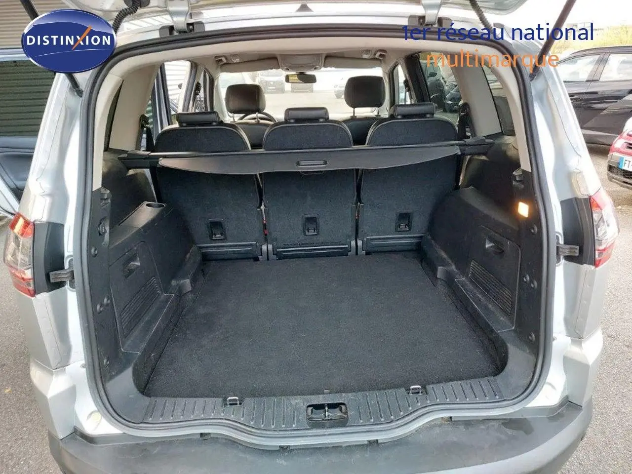 Coffre ouvert d'un Ford S-MAX gris clair métal de 2012, montrant l'espace de chargement et la banquette arrière.
