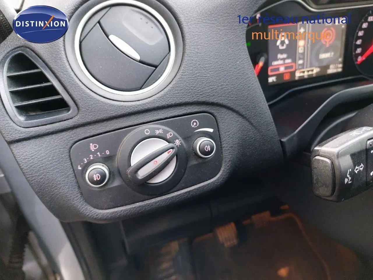 Gros plan sur la commande des phares et l'aération côté gauche du tableau de bord d'un Ford S-MAX gris clair 2012.