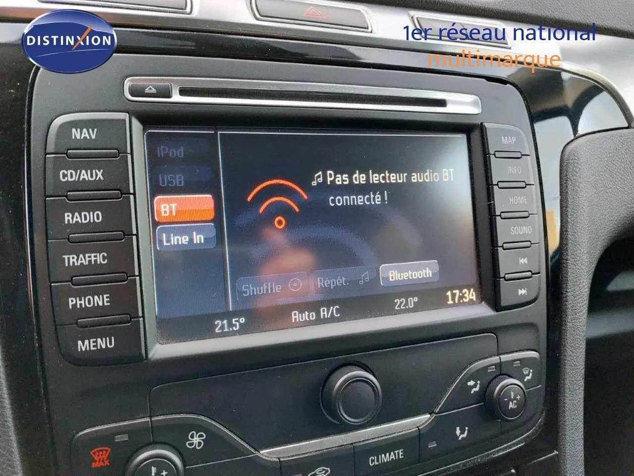 Gros plan sur l’écran multimédia et la console centrale du Ford S-MAX gris clair, affichant les options Bluetooth et climatisation.