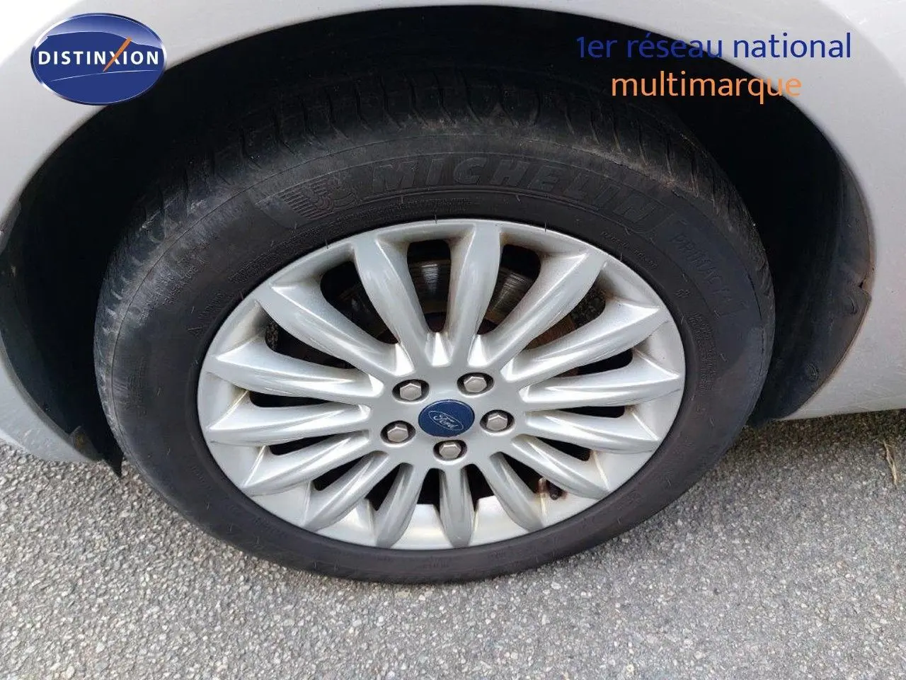 Gros plan sur la roue avant droite gris clair métal d'une Ford S-MAX 2012 avec jante alliage multibranches.