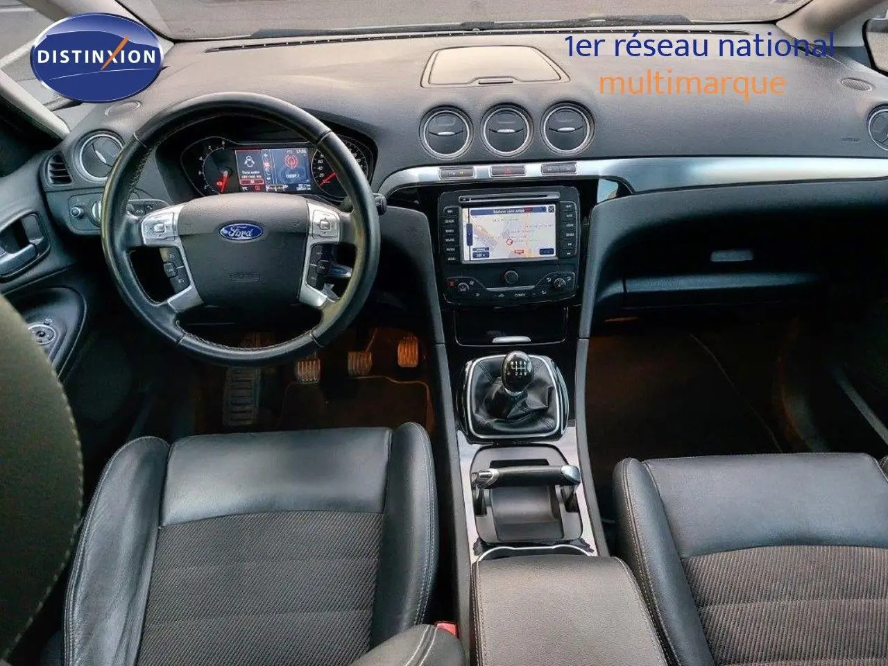 Vue intérieure de la Ford S-MAX 2012 montrant le tableau de bord noir avec GPS et levier de vitesses manuel.