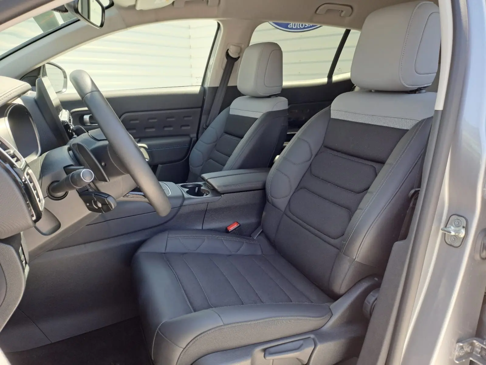 Vue intérieure côté conducteur du Citroën C5 Aircross 2024, sièges noirs avec appuie-tête gris clair et tableau de bord moderne.