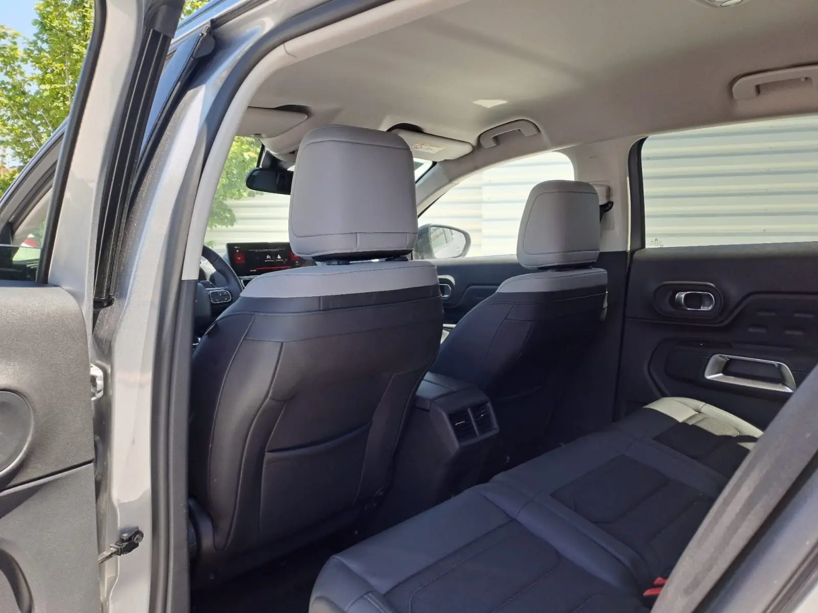Vue intérieure arrière du Citroën C5 Aircross gris Artense, sièges bi-ton noir et gris avec détails modernes.