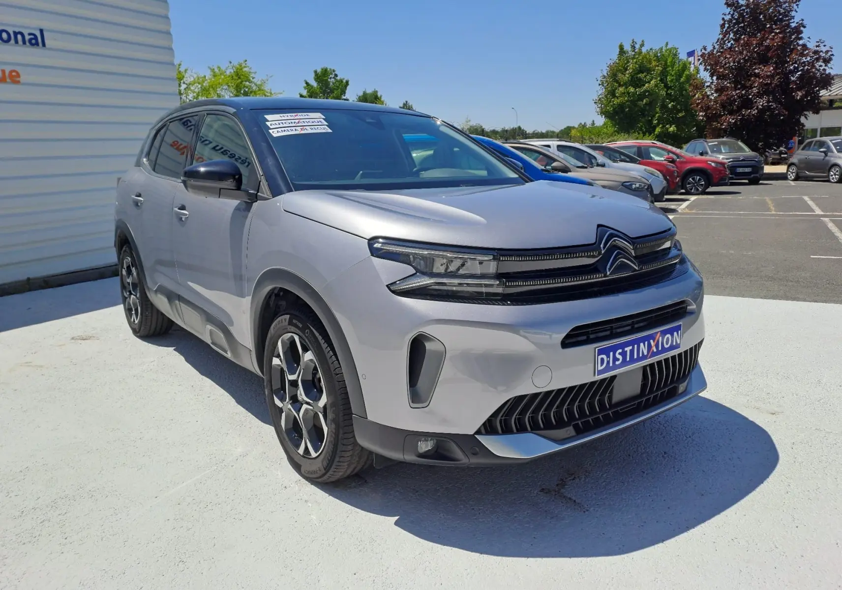 Citroën C5 Aircross gris Artense avec toit noir, vue 3/4 avant droit, sur parking ensoleillé.