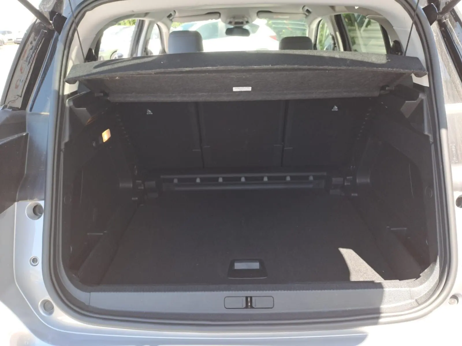 Coffre ouvert d'un Citroën C5 Aircross gris Artense avec toit noir, vue arrière montrant l'espace de chargement vide.