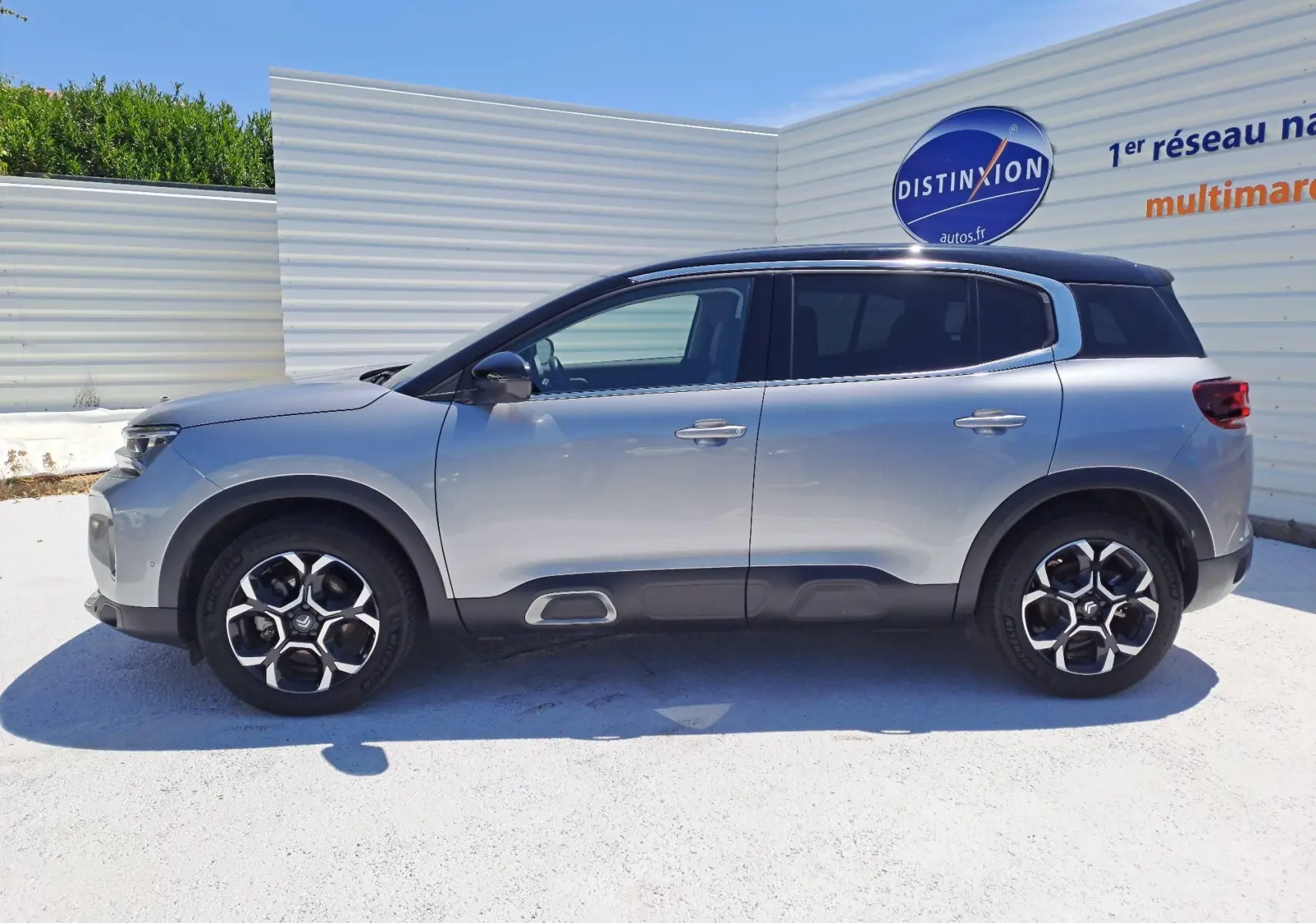 Vue latérale droite d'un Citroën C5 Aircross 2024 gris Artense avec toit noir, soulignant son design SUV moderne.