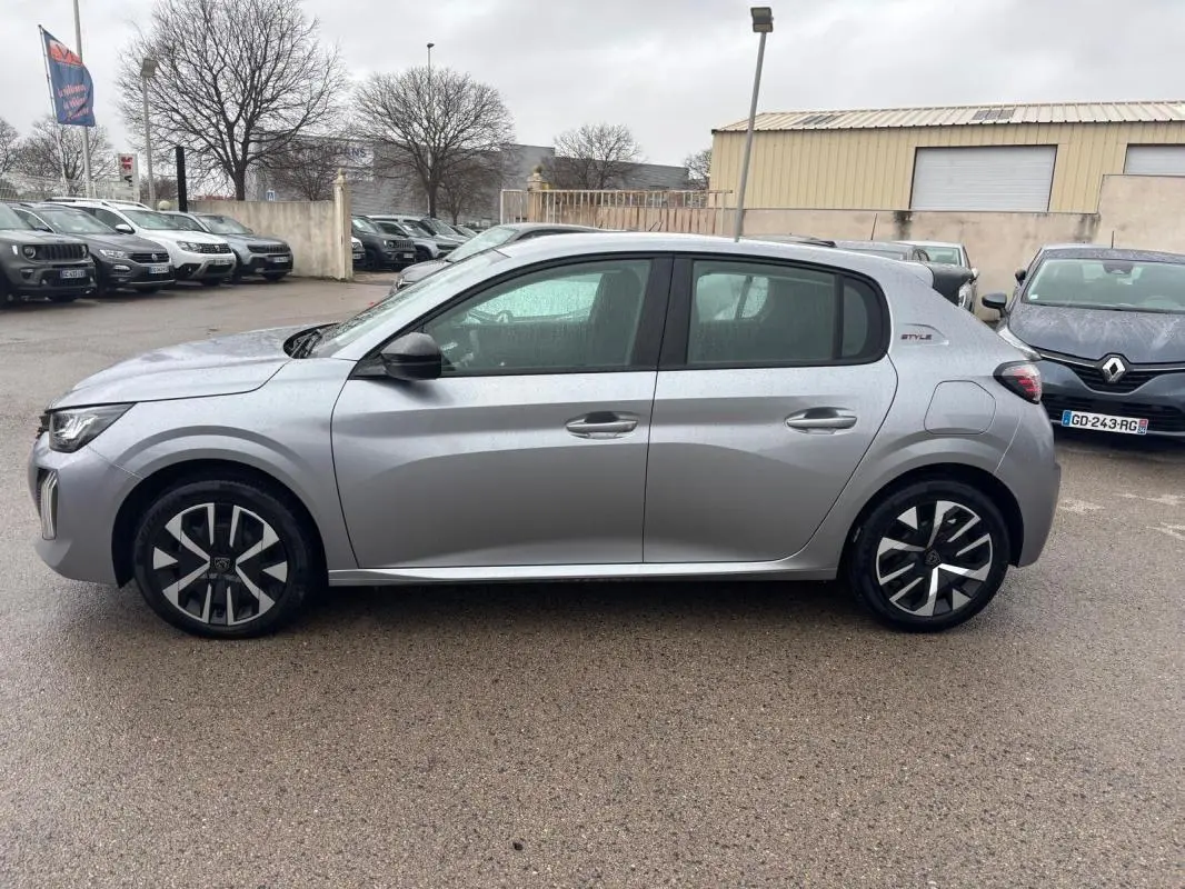 Vue de profil côté gauche d'une Peugeot 208 Hybrid 100 e-DCS6 Style gris avec jantes 16 pouces et badge Style arrière.