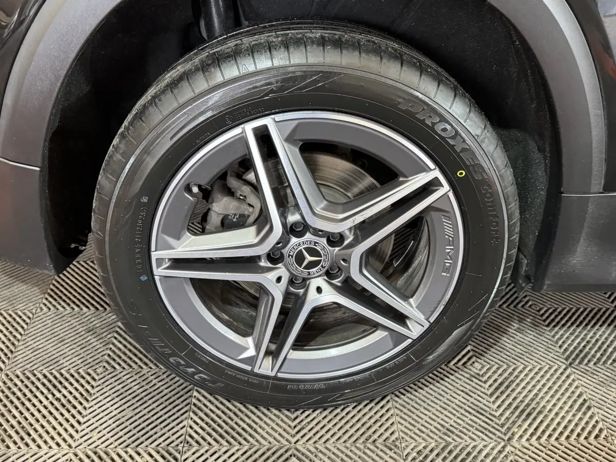 Gros plan sur la roue avant droite du Mercedes GLB 200 d AMG Line noir, avec jante AMG à cinq branches.