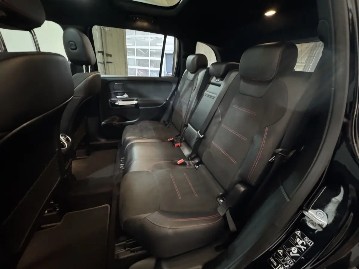 Vue intérieure côté droit des sièges arrière noirs avec surpiqûres rouges du Mercedes GLB 200 d AMG Line 2020.