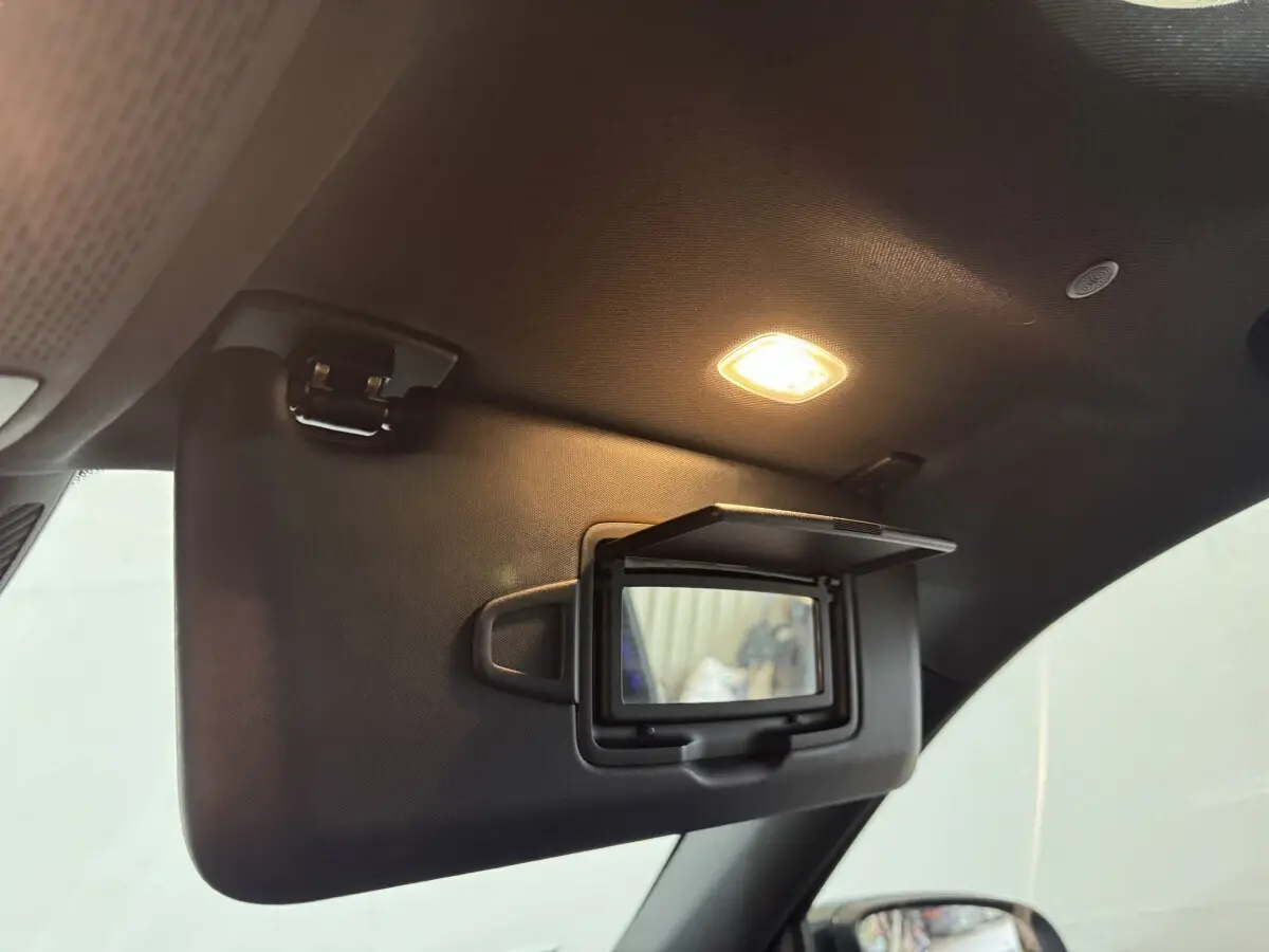 Détail intérieur du pare-soleil côté conducteur avec miroir éclairé dans le Mercedes GLB 200 d AMG Line noir.