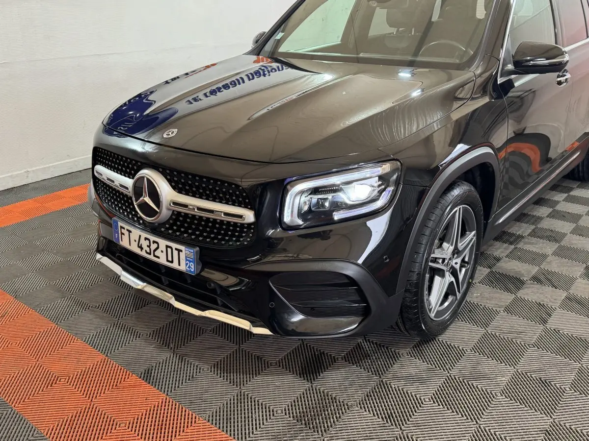 Vue 3/4 avant droit d’un Mercedes GLB 200 d AMG Line noir avec jantes alliage et calandre étoile distinctive.
