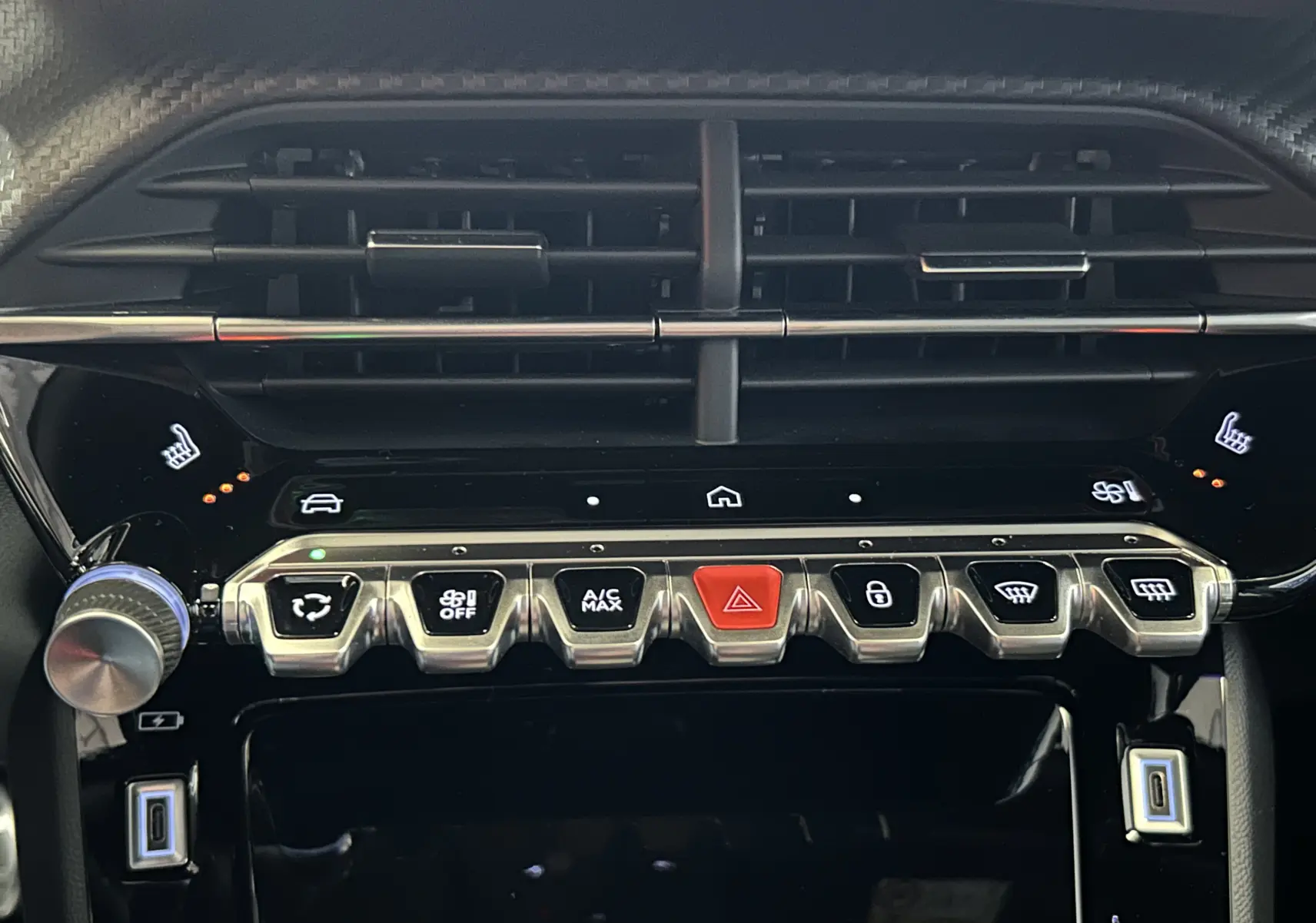 Vue rapprochée de la console centrale noire du Peugeot 2008 Hybrid 2025, avec boutons chromés et commandes tactiles.