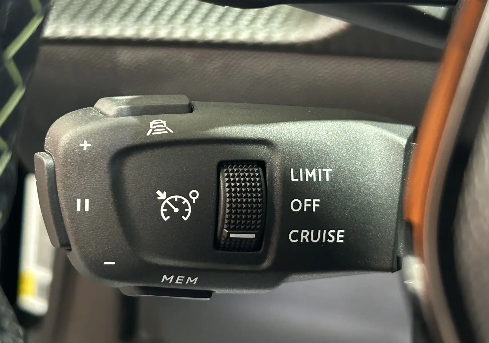 Gros plan sur la commande de régulateur de vitesse au volant d’un Peugeot 2008 noir, avec options Limit, Off, Cruise.