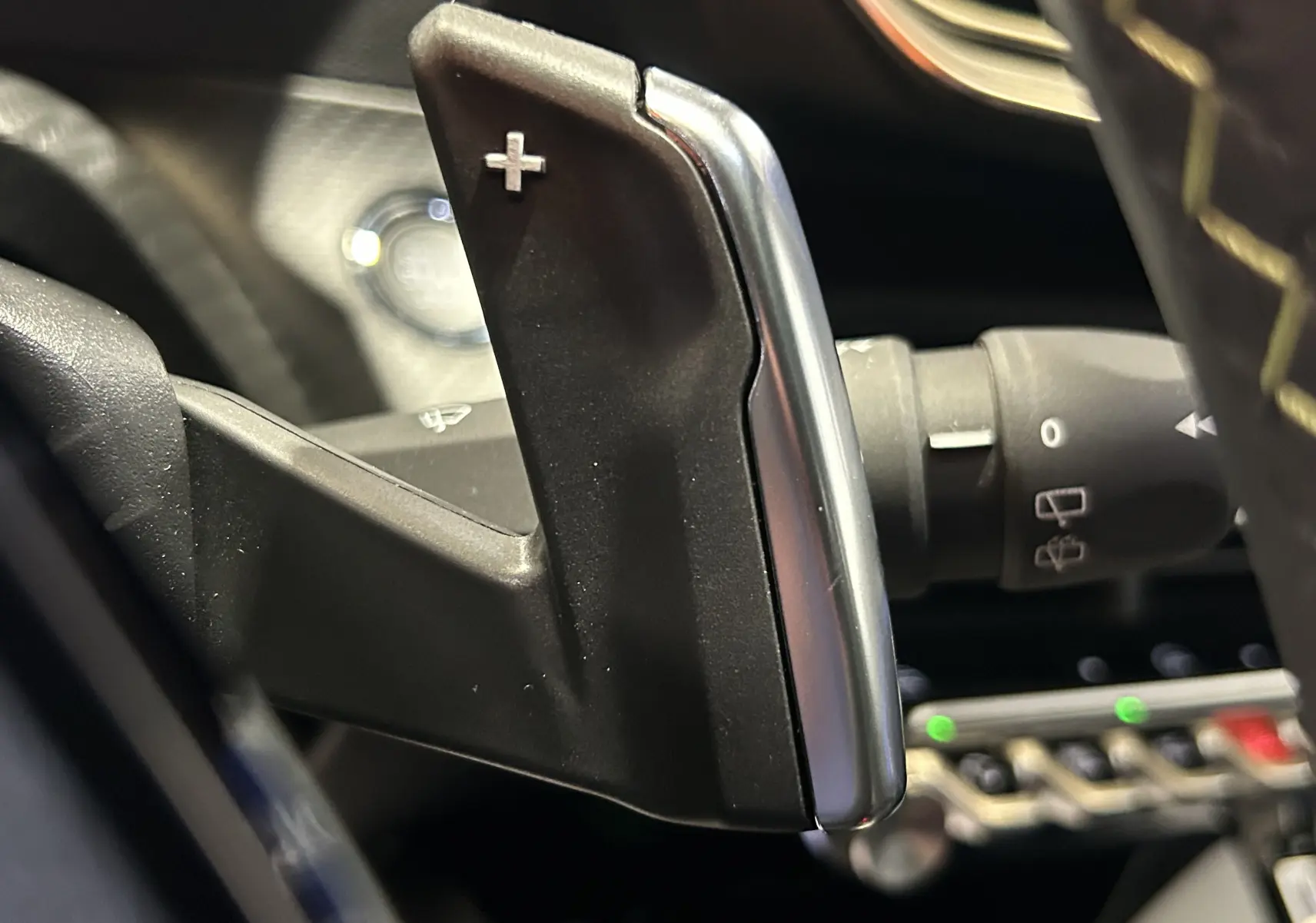Gros plan sur la palette de changement de vitesse droite noire et argentée du Peugeot 2008 Hybrid 136 e-DCS6 GT, intérieur moderne.