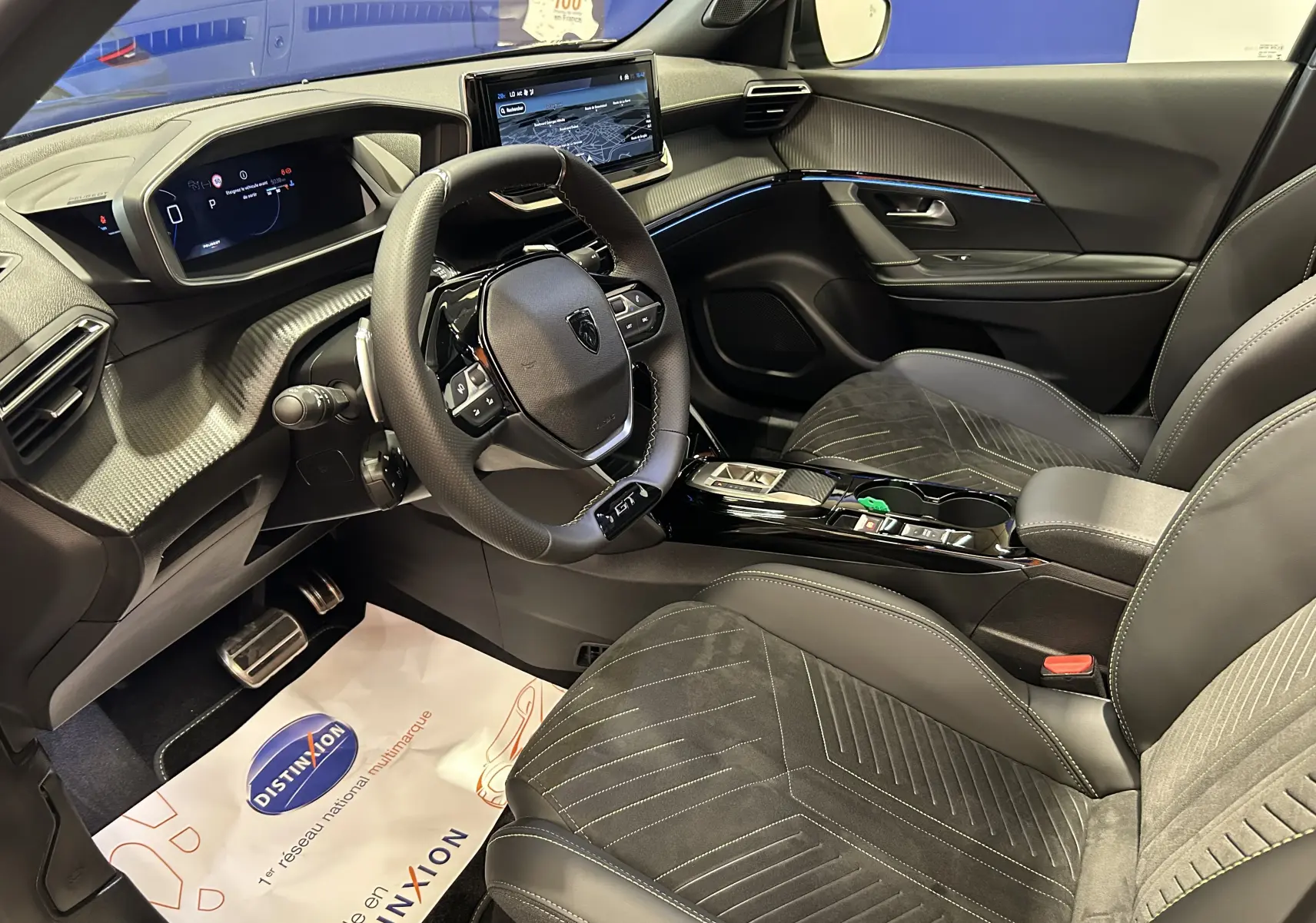 Vue intérieure côté conducteur du Peugeot 2008 Hybrid 136 e-DCS6 GT noir, avec sièges en cuir et écran tactile GPS.