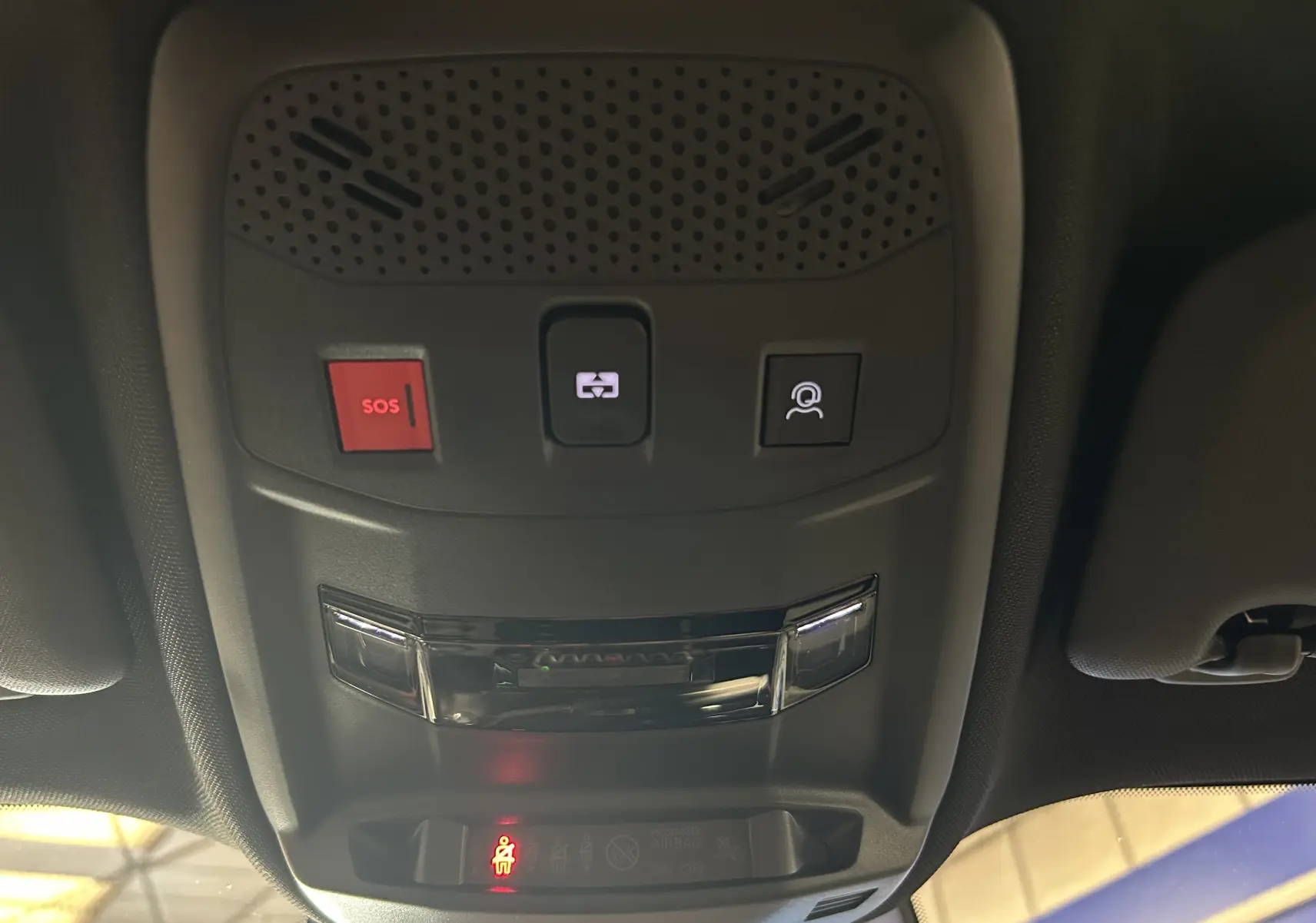 Vue en contre-plongée du plafonnier noir avec boutons SOS, appel et éclairage intérieur du Peugeot 2008 Hybrid 136 e-DCS6 GT.