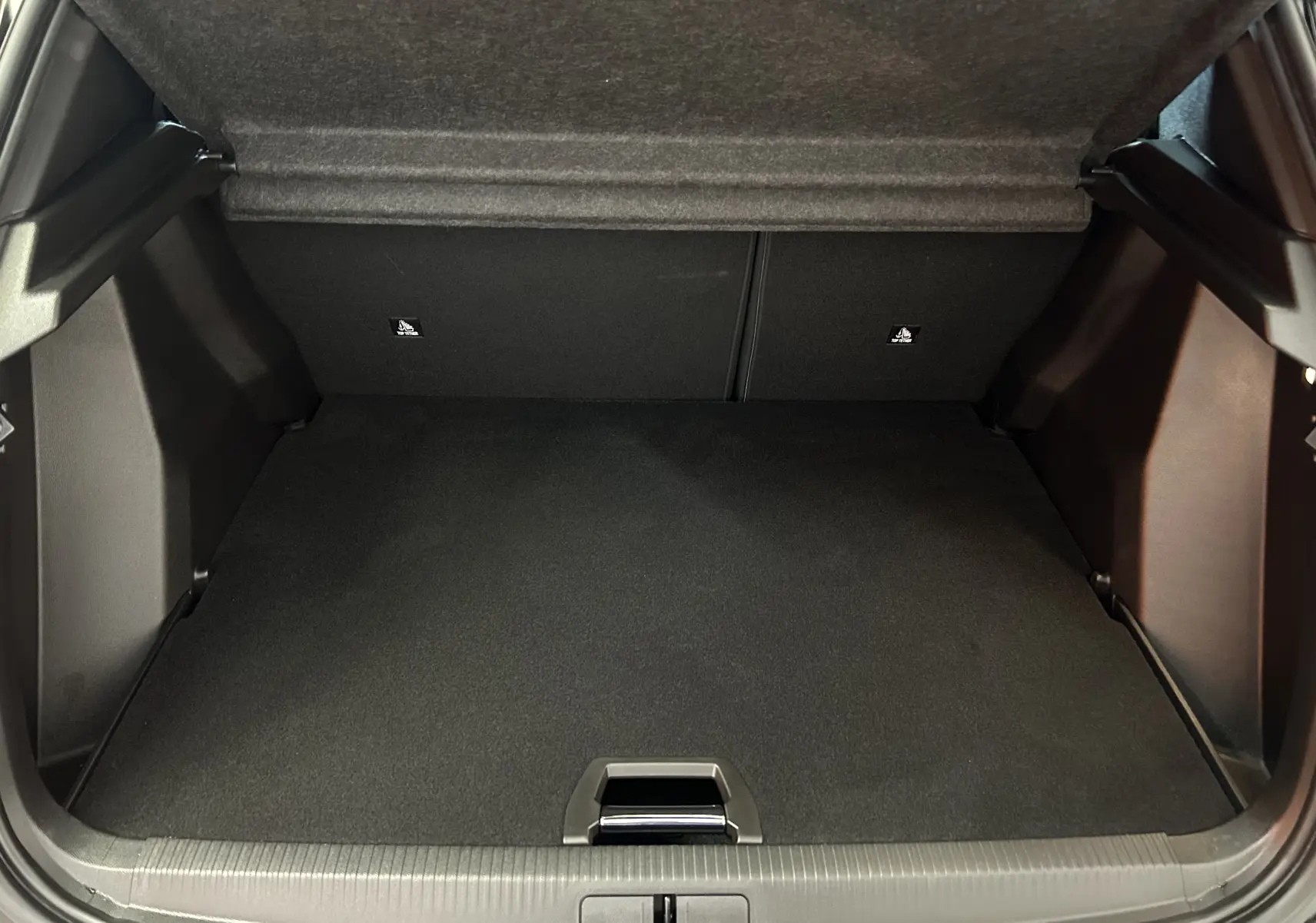 Coffre ouvert vu de l'arrière, montrant l'espace de chargement noir du Peugeot 2008 Hybrid 136 e-DCS6 GT.