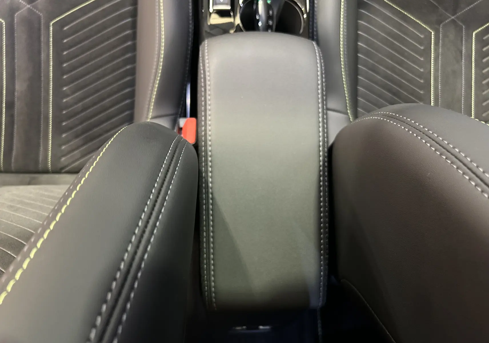 Vue rapprochée du coffre central en cuir noir avec surpiqûres contrastantes dans l’habitacle du Peugeot 2008 Hybrid 136 e-DCS6 GT.