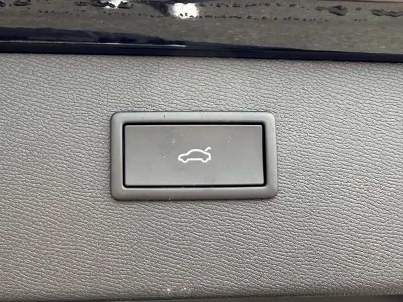 Bouton intérieur gris pour ouverture électrique du coffre sur tableau de bord d'une CUPRA Formentor bleu.