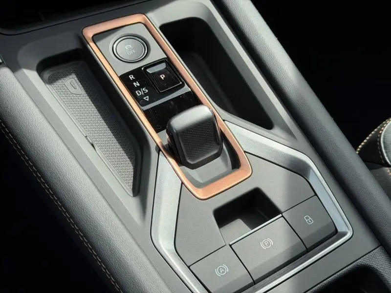Gros plan sur la console centrale du CUPRA Formentor bleu, avec levier de vitesse automatique et contour cuivre.