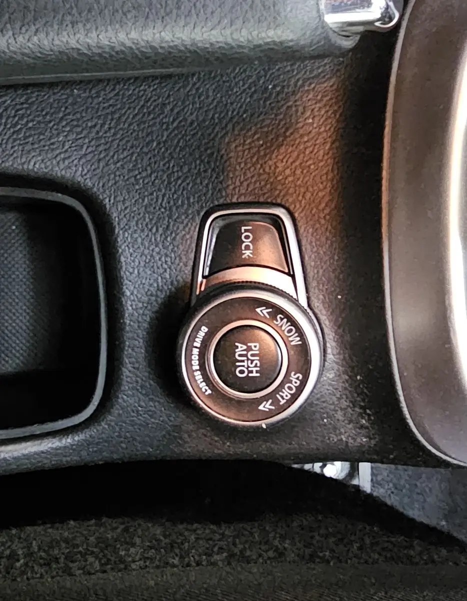 Gros plan sur la molette de sélection de mode de conduite et frein à main en cuir noir dans le Suzuki SX4 S-Cross 2020.