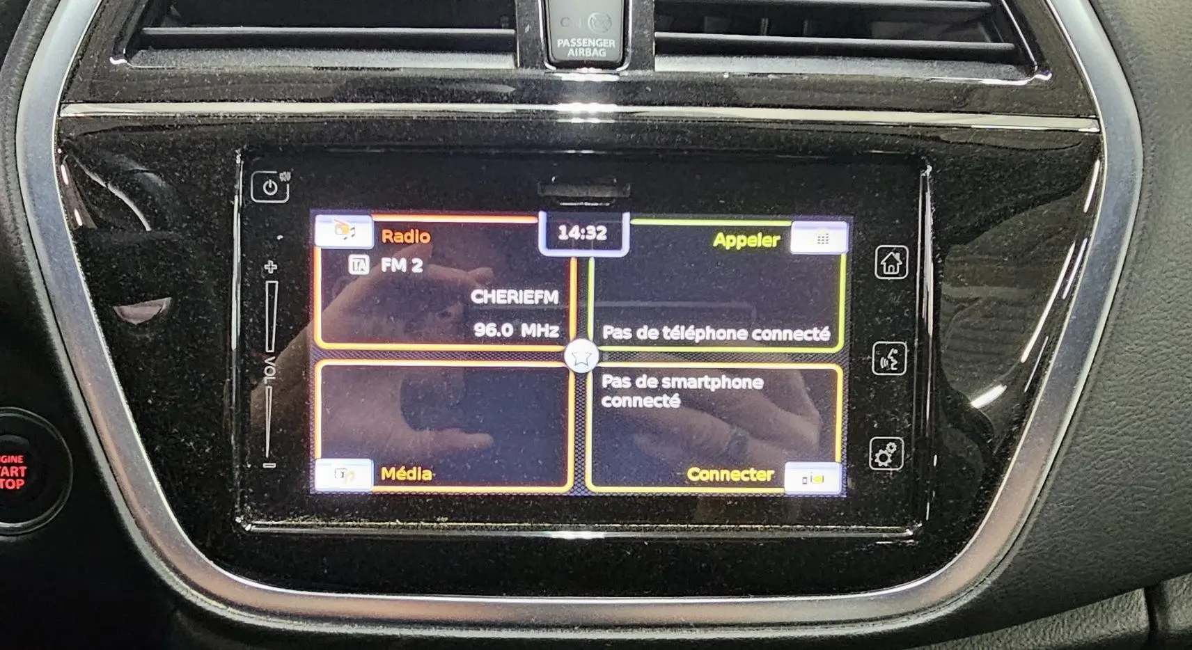 Écran tactile central du Suzuki SX4 S-Cross 2020 affichant radio FM et options de connexion smartphone, avec bouton start/stop rouge à gauche.